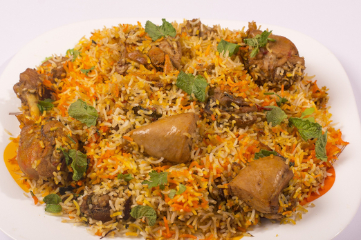 Aromatisches Chicken Biryani mit Basmatireis, zartem Hähnchen und frischen Kräutern auf einem Teller angerichtet